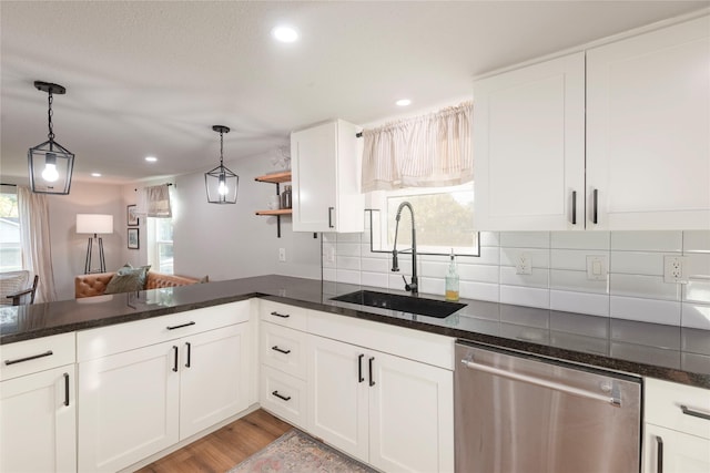 kitchen featuring white cabinets, backsplash, stainless steel dishwasher, open shelves, and a sink