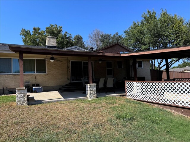 back of property with a lawn and ceiling fan