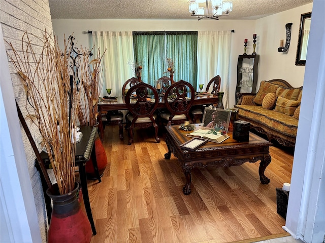 living room featuring hardwood / wood-style floors, a textured ceiling, and an inviting chandelier