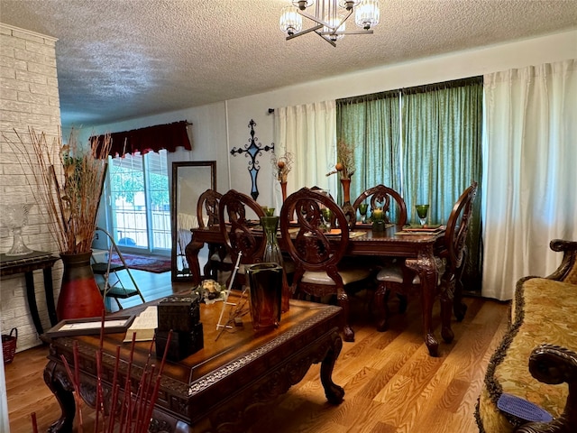 dining area featuring hardwood / wood-style floors, a textured ceiling, and a notable chandelier