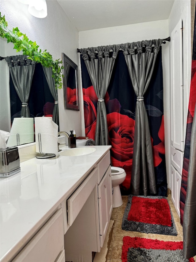 bathroom with tile patterned flooring, vanity, and toilet