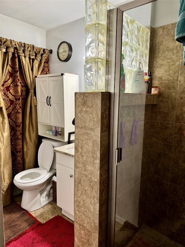 bathroom featuring toilet, vanity, a textured ceiling, and walk in shower