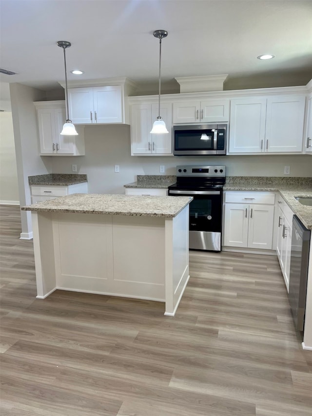 kitchen with light wood-type flooring, light stone counters, stainless steel appliances, white cabinets, and hanging light fixtures