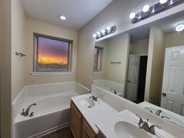 bathroom with a tub, tile patterned flooring, and vanity