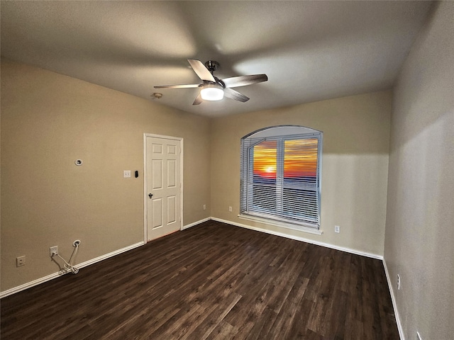 empty room featuring ceiling fan and dark wood-type flooring