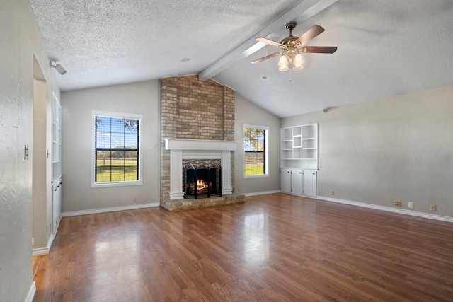 unfurnished living room with ceiling fan, dark hardwood / wood-style flooring, a textured ceiling, and a brick fireplace