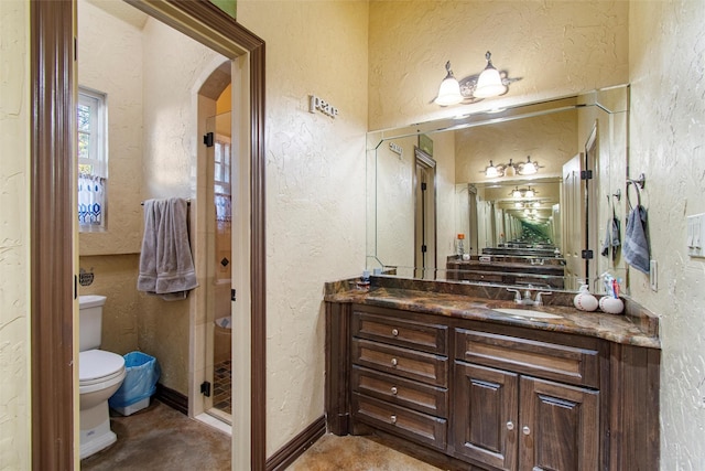 bathroom featuring vanity, toilet, and a shower with shower door