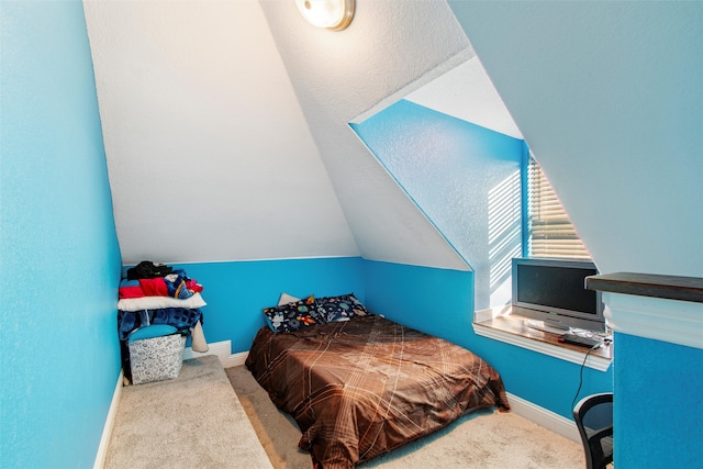 carpeted bedroom with lofted ceiling