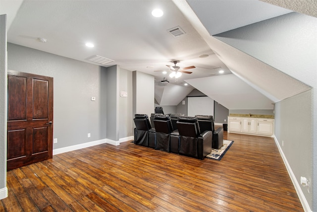 cinema room featuring a textured ceiling, ceiling fan, dark wood-type flooring, and vaulted ceiling