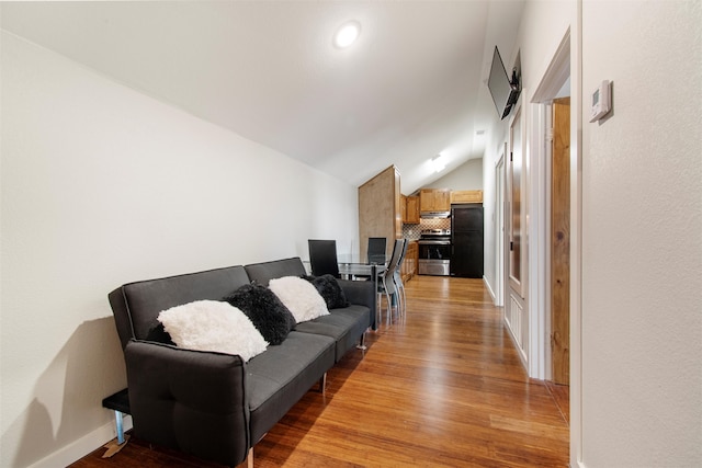 living room featuring lofted ceiling and light hardwood / wood-style flooring