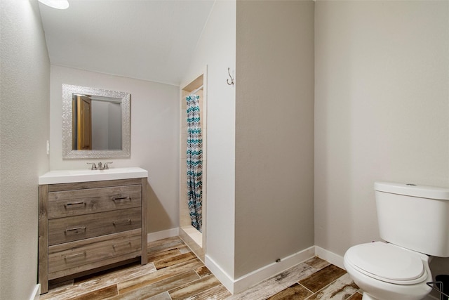 bathroom featuring walk in shower, vanity, wood-type flooring, and toilet