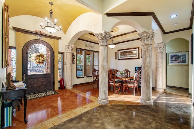 entryway with lofted ceiling, french doors, ornamental molding, a notable chandelier, and decorative columns