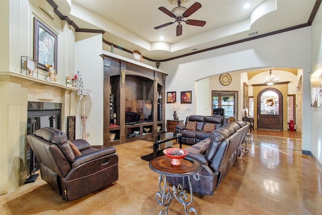 living room with ceiling fan with notable chandelier, a raised ceiling, and crown molding