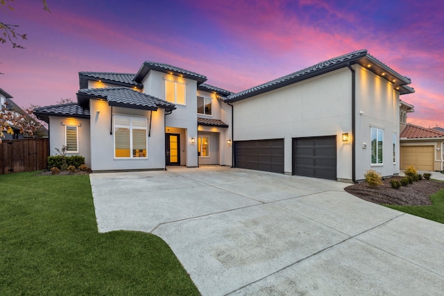 view of front of property with a garage and a yard