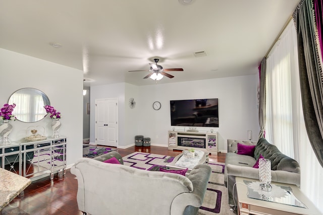 living room with ceiling fan and dark wood-type flooring