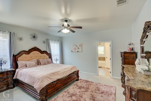 carpeted bedroom with ensuite bathroom and ceiling fan