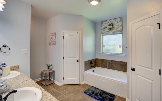 bathroom featuring tile patterned flooring, vanity, and a tub