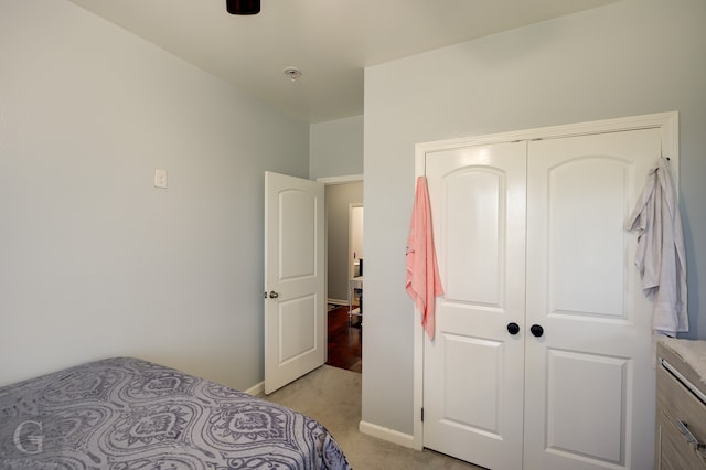 bedroom featuring light colored carpet, a closet, and ceiling fan