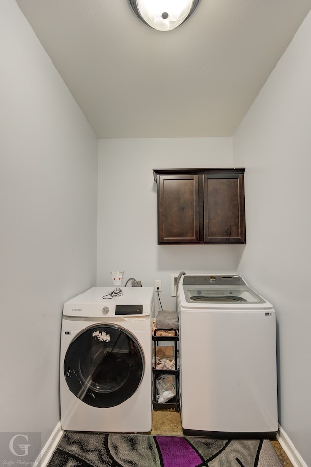 clothes washing area with cabinets and independent washer and dryer