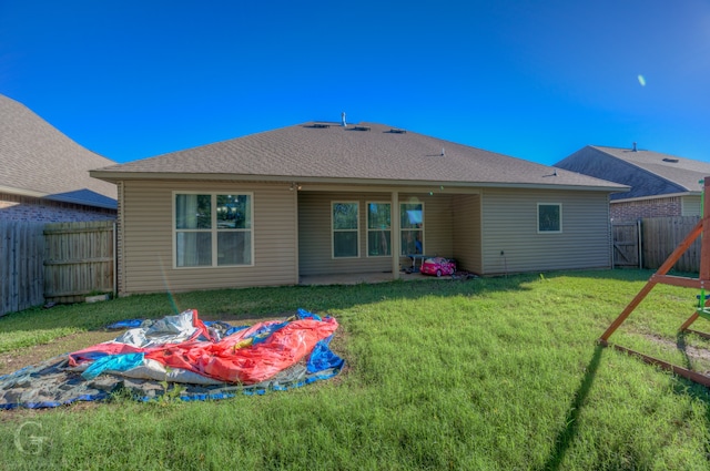 rear view of property featuring a yard