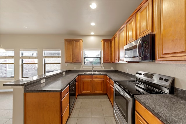 kitchen with kitchen peninsula, sink, light tile patterned floors, and stainless steel appliances