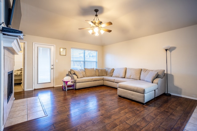 living room with vaulted ceiling, ceiling fan, and dark wood-type flooring