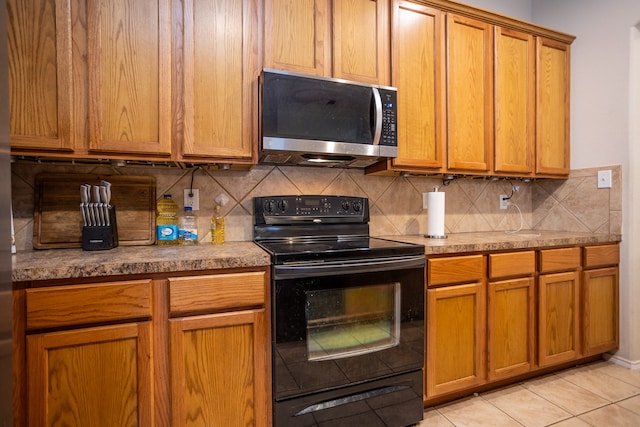 kitchen with light tile patterned flooring, tasteful backsplash, and black / electric stove