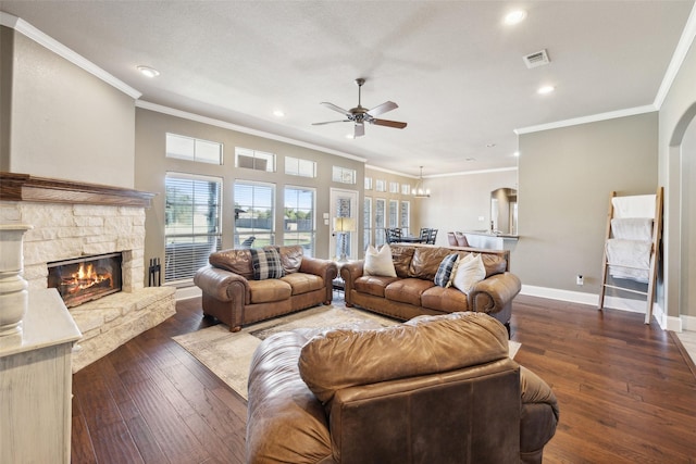 living room with ceiling fan, dark hardwood / wood-style flooring, ornamental molding, and a fireplace