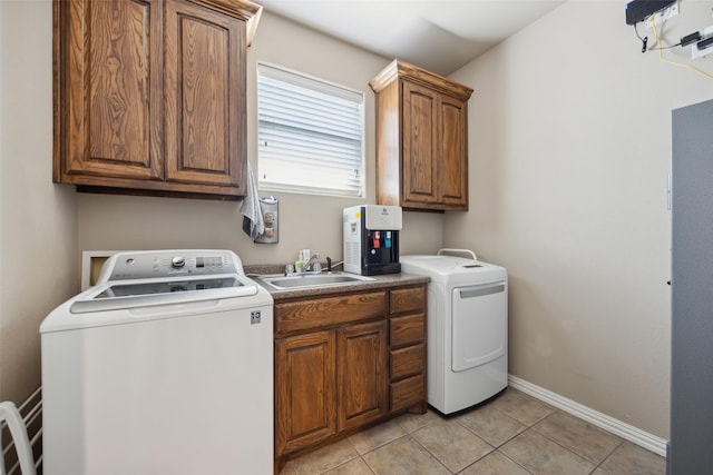 laundry room with sink, cabinets, washing machine and dryer, and light tile patterned floors