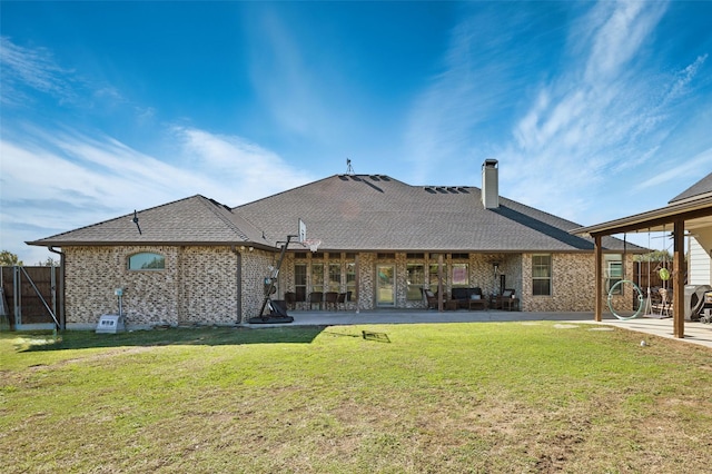 rear view of house with a patio and a lawn