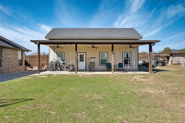 rear view of house with a patio, ceiling fan, and a lawn