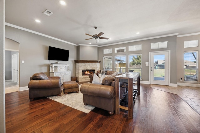 living room featuring a fireplace, wood-type flooring, ceiling fan, and a healthy amount of sunlight