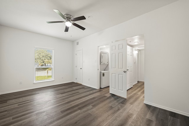 interior space featuring dark hardwood / wood-style flooring, ceiling fan, and stacked washer and dryer