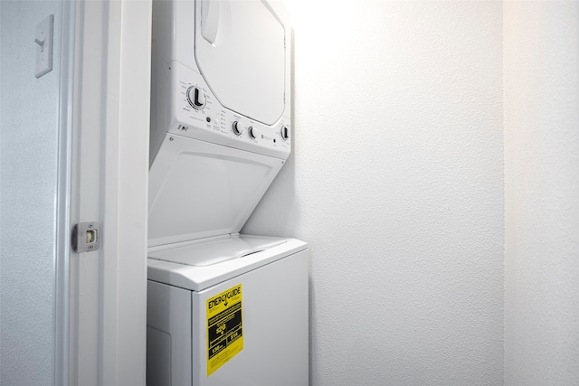 clothes washing area featuring stacked washer / drying machine