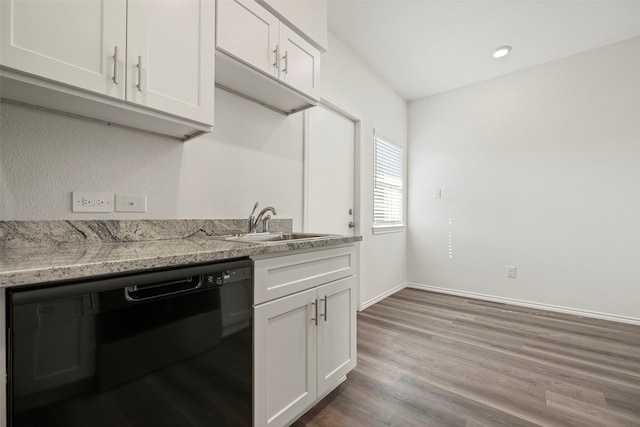 kitchen featuring light stone countertops, white cabinetry, dishwasher, sink, and hardwood / wood-style floors