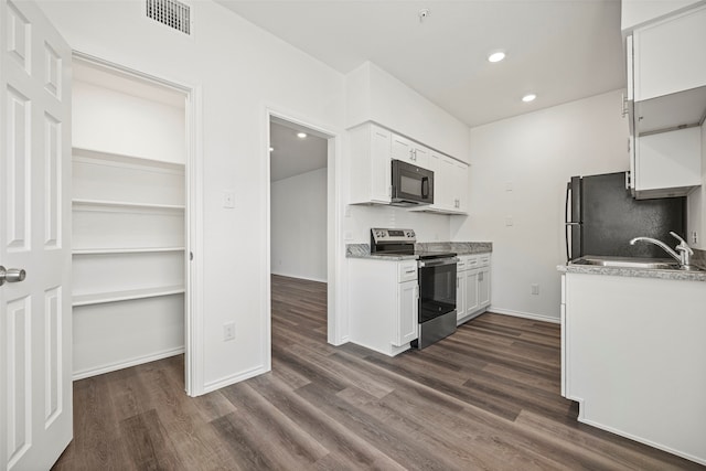 kitchen with stainless steel electric stove, sink, white cabinets, and dark wood-type flooring