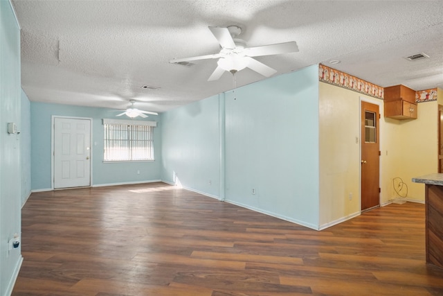 empty room with a textured ceiling, ceiling fan, and dark wood-type flooring