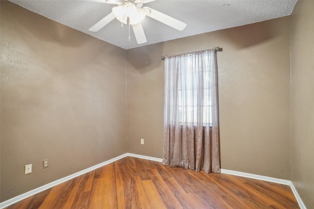 empty room with hardwood / wood-style flooring, ceiling fan, and a textured ceiling