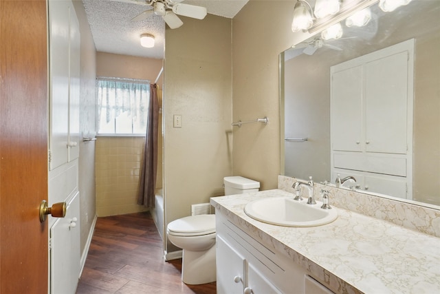 full bathroom with wood-type flooring, a textured ceiling, toilet, shower / bath combo with shower curtain, and vanity