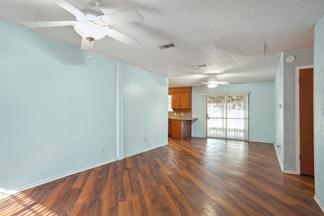 unfurnished living room featuring a textured ceiling, dark hardwood / wood-style floors, and ceiling fan