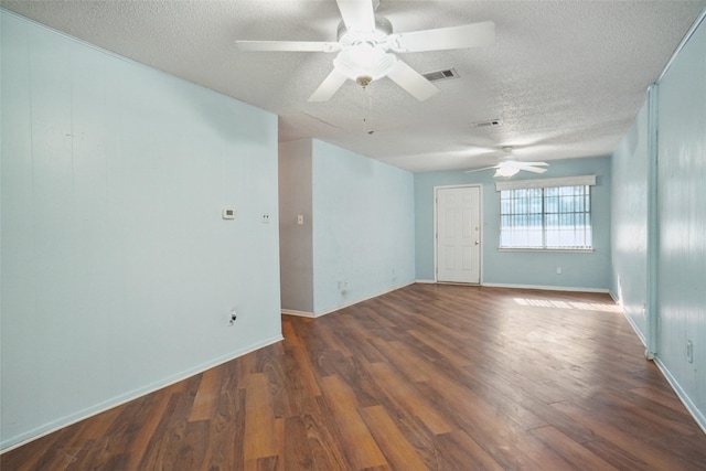 empty room with ceiling fan, dark wood-type flooring, and a textured ceiling