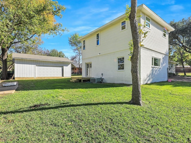 view of home's exterior featuring a garage, an outdoor structure, a yard, and central AC unit