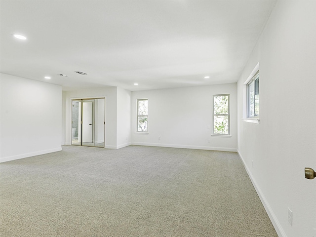 unfurnished room featuring light carpet