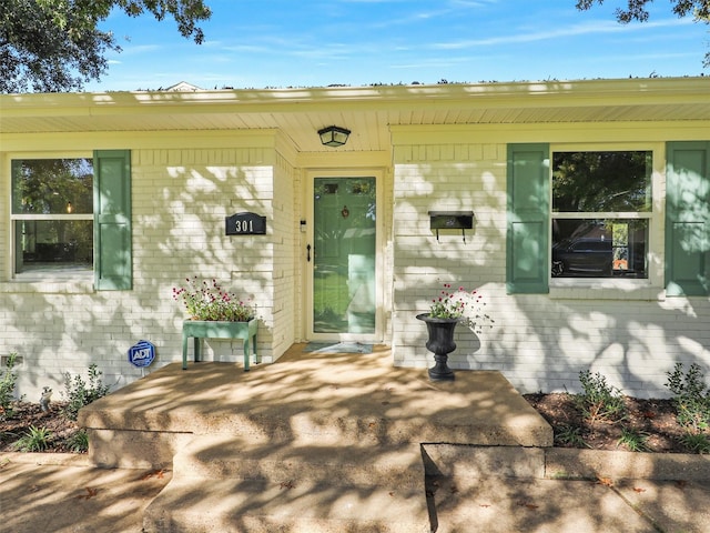 view of exterior entry with a patio area