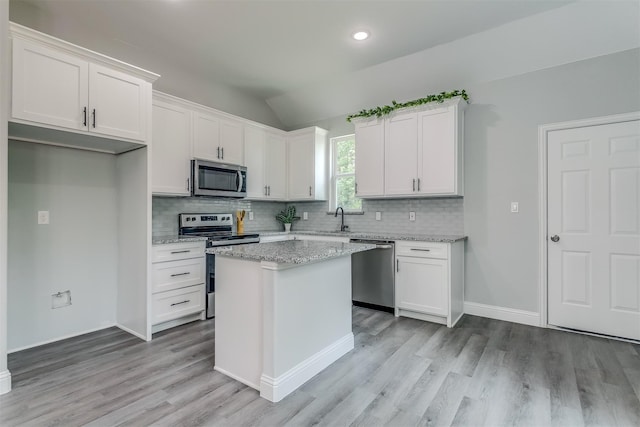 kitchen featuring white cabinetry, a center island, lofted ceiling, and appliances with stainless steel finishes