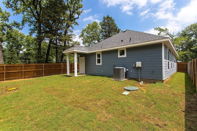 back of house featuring central AC and a lawn