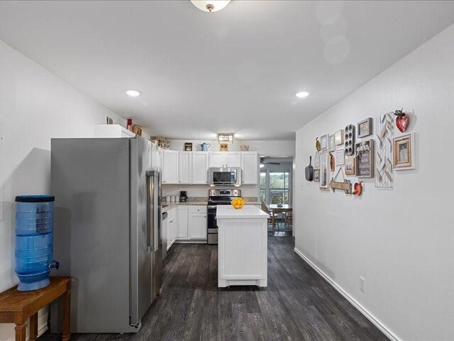 kitchen with white cabinets, stainless steel appliances, and dark wood-type flooring