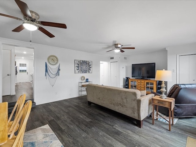 living room featuring dark hardwood / wood-style flooring, ceiling fan, and crown molding