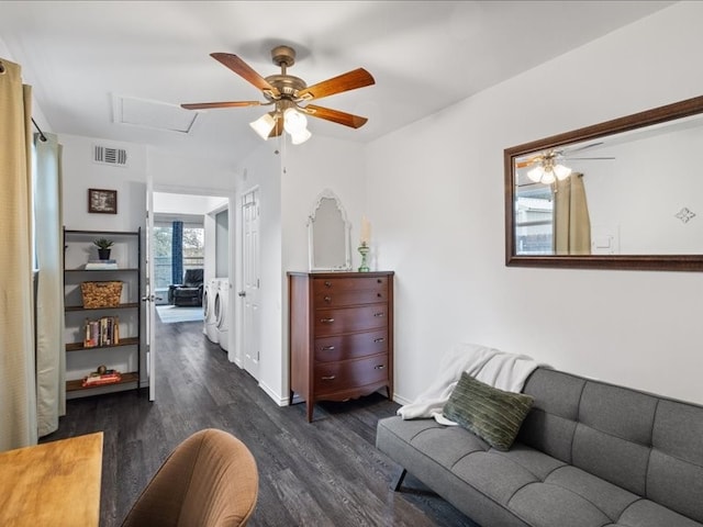 living room featuring washer and clothes dryer, ceiling fan, and dark wood-type flooring