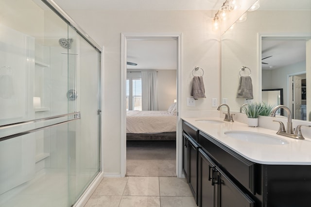 bathroom with tile patterned floors, ceiling fan, a shower with door, and vanity